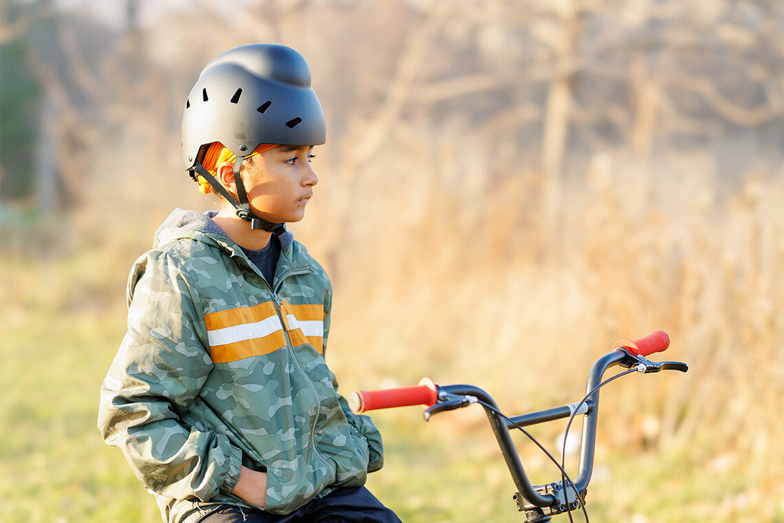 A child on a bike wearing one of Tina Singh's helmets